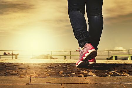 Frau mit Turnschuhen geht neuen Weg