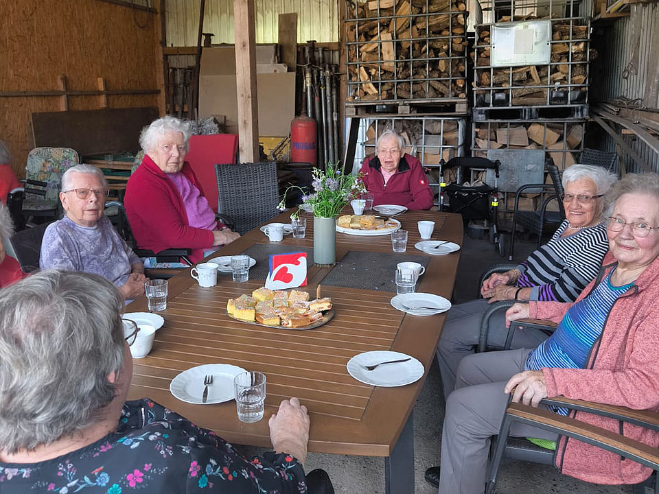 Die BewohnerInnen bei Kaffe und Kuchen in der Scheune