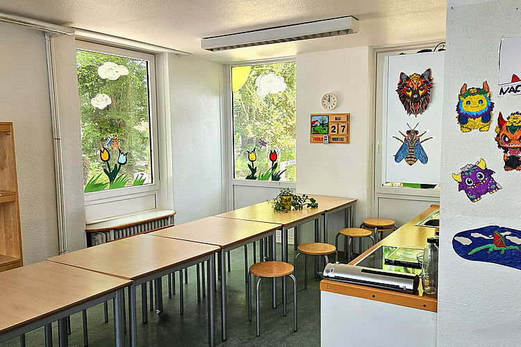 Elterngruppenraum mit einem langen Tisch und Stühlen